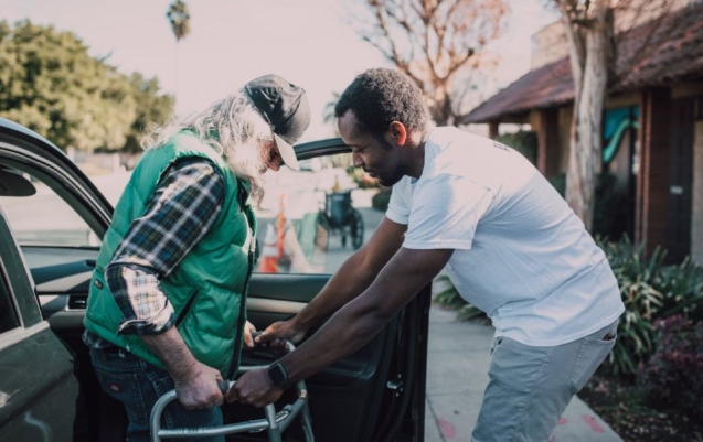 Male support worker doing support with personal activities for an elderly woman.